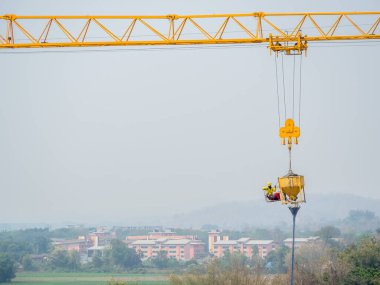 İnşaat işçileri, güvenlik riskleriyle beton döken makineleri kontrol etmek için vinçlerle asıldı..