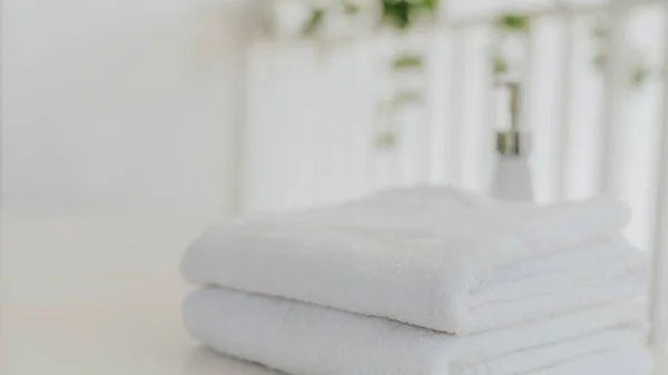 Laundry white towel with shampoo and shower cream bottle in bathroom with copy space.