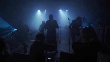 Bir müzik grubu bir barda küçük bir sahnede sahne alır, seyirci sahnenin önündedir.