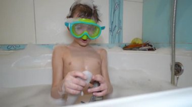 Maskeli çocuk banyoda oynuyor.
