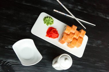 Aperatif suşi Japon yemeği ve pilav. Beyaz mutfak tahtasında kırmızı ve yeşil makarna. 