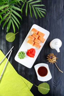 Aperatif suşi Japon yemeği ve pilav. Beyaz mutfak tahtasında kırmızı ve yeşil makarna. 