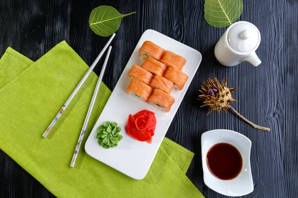Aperatif suşi Japon yemeği ve pilav. Beyaz mutfak tahtasında kırmızı ve yeşil makarna. 