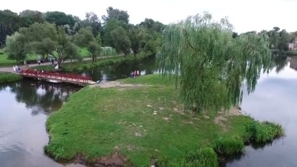 Parque com uma ponte do outro lado do lago para a ilha — Vídeo de Stock