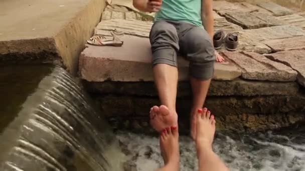 Füße im Wasser in der Nähe des Wasserfalls — Stockvideo