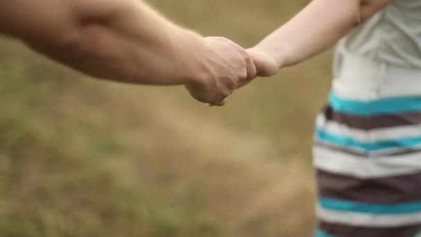 Гай и девочка держутся за руки — стоковое видео
