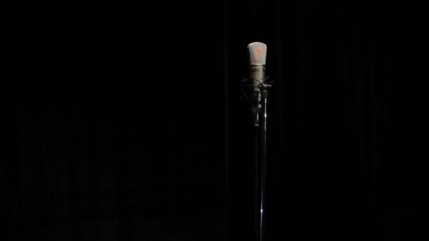 Cantora de microfone em um fundo preto — Vídeo de Stock