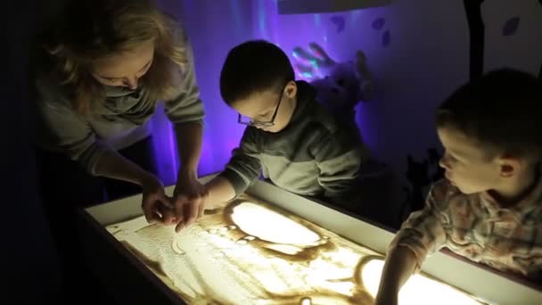 Kinderen Tekenen Met Hun Handen Het Zand Met Verlichting — Stockvideo
