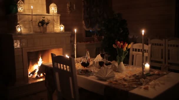 暖炉のそばの明かりで愛するカップルが婚約暖炉近くろうそくの明かりで夕食をとっている 愛するカップル ダインズします — ストック動画