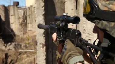 Asker arms.young askerler silahlı, ekipman bir asker ve silah ile savaşta harap bir ev şehir dışında olup olmadığını denetler.