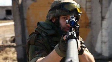 Askeri silah ile savaş. Genç askerlerin silahlı bir askeri ekipman ve silah ile şehir dışında harap bir ev inceler..