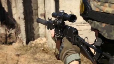 Askeri silah ile savaş. Genç askerlerin silahlı bir askeri ekipman ve silah ile şehir dışında harap bir ev inceler..