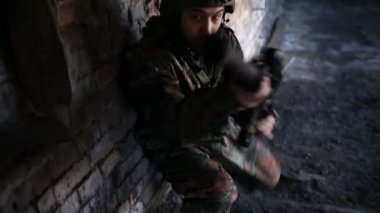 Harabelerin olduğu askeri operasyonda dinlenen düşünceli bir asker.