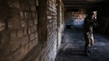 Silahlı genç askerler, teçhizatlı ve silahlı bir asker şehrin dışındaki harabe bir evi teftiş ediyor..