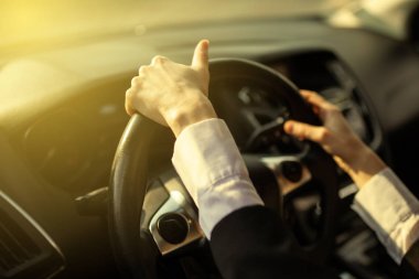 The girl holds her hands behind the wheel of the car clipart