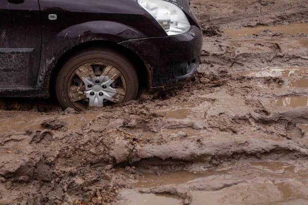 El coche está atascado en un mal camino en el barro — Foto de Stock