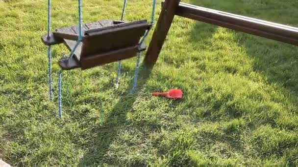 Los niños oscilan en el patio de recreo — Vídeo de stock