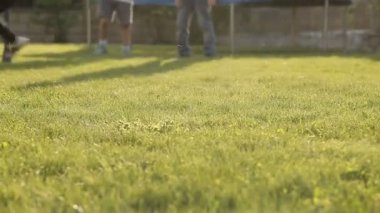 Çimde futbol topuyla oynayan çocuklar