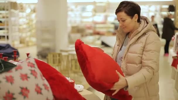 Mujer elige vacaciones regalos de Navidad en el centro comercial . — Vídeo de stock