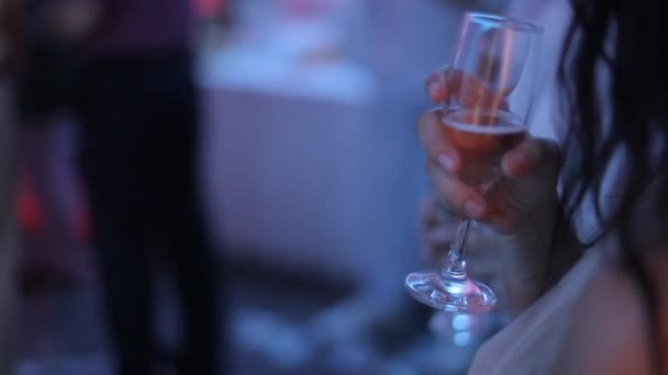 Женщина держит в руке бокал шампанского . — стоковое видео