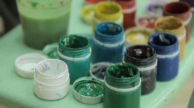 Plastik kavanozlarda çok renkli guaj seti. Döndürme çok renkli arka plan. Bir sürü varisli boya kavanozu.
