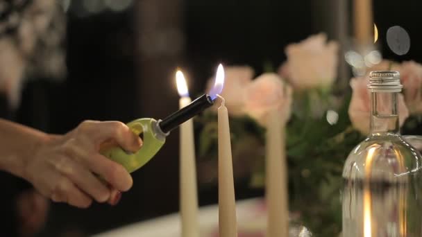 Дівчина запалює свічки на свічках. Романтична вечеря свічками . — стокове відео