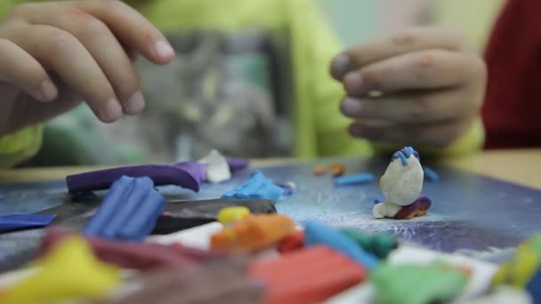 Niño esculpe una escultura hecha de arcilla de colores — Vídeos de Stock
