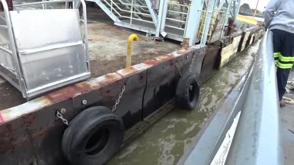 Un uomo, Moor Barge. Il marinaio lega la corda di ormeggio del traghetto ad un dissuasore sul molo . — Video Stock