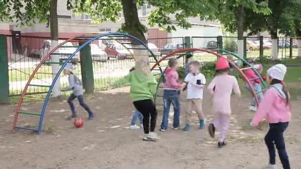 Sok gyerek játszik a szabadban a játszótéren. — Stock videók