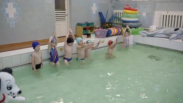 Два мальчика купаются в бассейне. Плавание в школьном бассейне. Парни учатся плавать. — стоковое видео