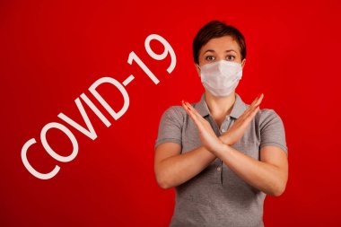 Maskeli bir kadın COVID-19 virüsünün yayılmasını durdurduğunu gösteriyor. Salgının yayılmasını önleme ve koronavirüsü tedavi etme kavramı. Coronavirüs tedavisi.