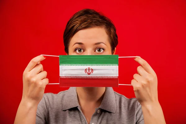 イランのコロナウイルスCovid イランの国旗をイメージした医療用保護マスクの女性 流行の広がりを防止し コロナウイルスを治療するという概念 — ストック写真
