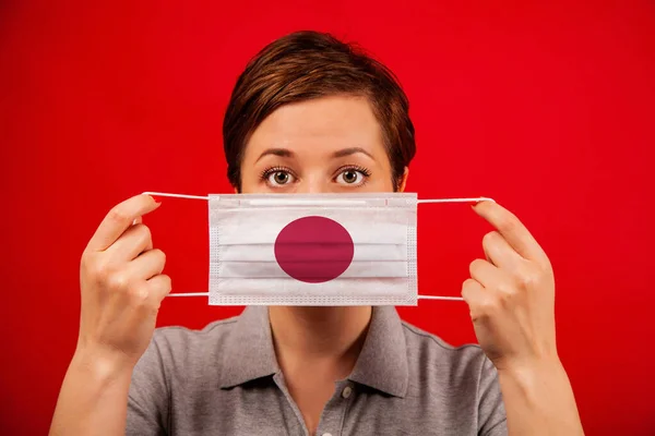 日本ではコロナウイルスCovid 日本の国旗をイメージした医療用保護マスクの女性 流行の広がりを防止し コロナウイルスを治療するという概念 — ストック写真