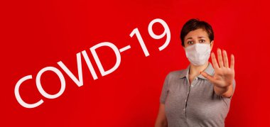 Maskeli bir kadın COVID-19 virüsünün yayılmasını durdurduğunu gösteriyor. Salgının yayılmasını önleme ve koronavirüsü tedavi etme kavramı. Coronavirüs tedavisi.