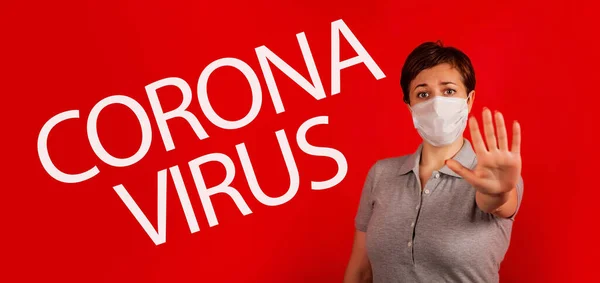 A woman in a mask indicates stopping the spread of the COVID-19 virus.. The concept of preventing the spread of the epidemic and treating coronavirus. — Stock Photo, Image