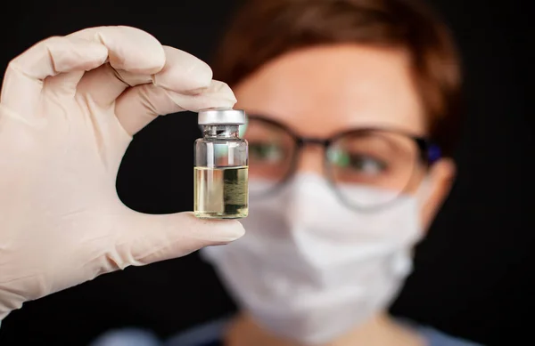 Ein Arzt oder eine Krankenschwester in Nitrilhandschuhen hält einen Impfstoff in der Hand, der gegen Grippe, Masern, Coronavirus COVID geimpft ist — Stockfoto