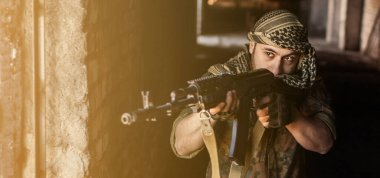 Ulusal Kefiyeh 'den başlıklı Arap erkek asker elinde bir silahla siyah arka planda silahlı bir Müslüman.