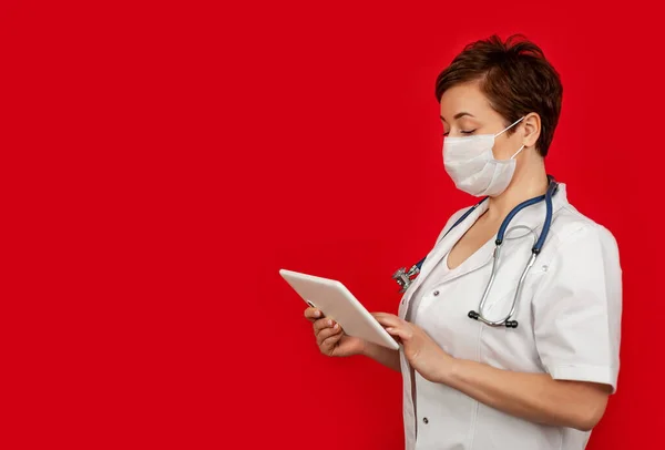 Retrato de una doctora usando su tableta digital. Médico femenino usando tableta y comprobando con análisis —  Fotos de Stock