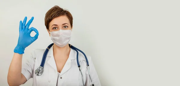 Trabajador médico que lleva una máscara protectora y muestra un signo aceptable . —  Fotos de Stock