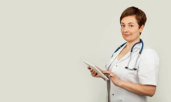 Портрет женщины-врача, использующей свой цифровой планшет. Женщина-врач с помощью таблеток и проверки с анализом — стоковое фото