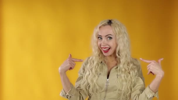En överraskad vacker kvinna, en medelålders blond, är förvånad över att vinna lotteriet, pekar på sig själv chockad — Stockvideo