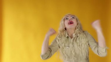 Neşeli, mutlu bir kadın, yumruğuyla elini kaldırıyor, takım için tezahürat yapıyor, kumarhanede büyük bir bahsi kazanıyor.