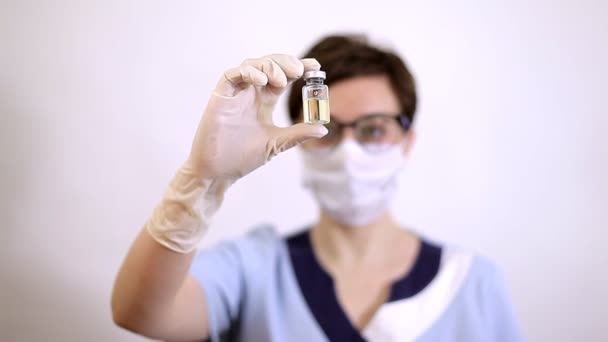 Lékař nebo sestra v nitrilových rukavicích drží v ruce očkovanou vakcínu — Stock video