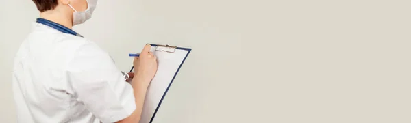 Ärztin schreibt mit einem Stift ein Dokument auf einem Tablet, schreibt eine Krankengeschichte. Das Konzept der Gesundheitsfürsorge, Medizin — Stockfoto