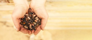 Bir askerin elindeki mermi kovanlarından çıkan kovanlar..