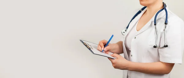 Ärztin schreibt mit einem Stift ein Dokument auf einem Tablet, schreibt eine Krankengeschichte. Das Konzept der Gesundheitsfürsorge, Medizin — Stockfoto