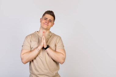 Avuçlarını birbirine bastıran yakışıklı bir adam.