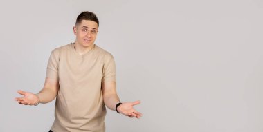 Genç adam gülümsüyor ve ellerini açıyor. Cevap olarak ne diyeceğini bilmiyor..