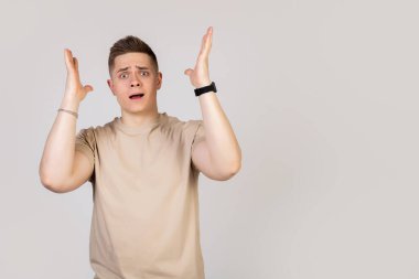 Guy, genç bir adam mutlu bir heyecanla ellerini tutuyor.,