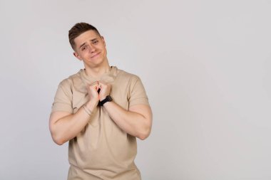 Avuçlarını birbirine bastıran yakışıklı bir adam.